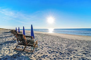 A beach with sun umbrellas and beach chairs.