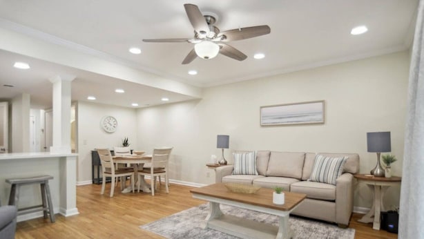 A modern living room with a sofa, coffee table, and dining area. - Beachy & Beautiful Renovated Villa Just Steps from (Hilton Head Island)