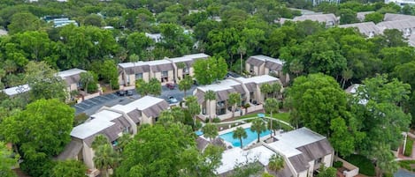 Een resort met meerdere gebouwen, een centraal gelegen zwembad en uitzicht op de oceaan.