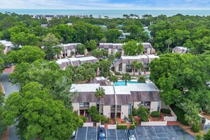 A resort with multiple buildings, a swimming pool, and lush greenery.