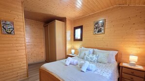 Una stanza con pannelli in legno, un letto, comodini e opere d'arte.