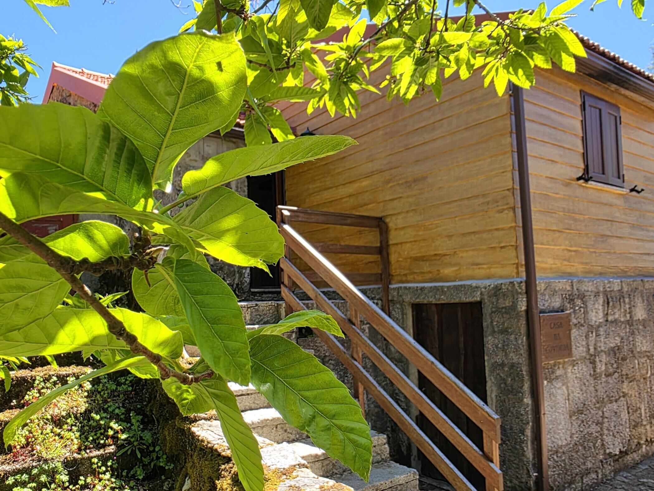 Un bâtiment en bois avec un escalier menant à une porte.