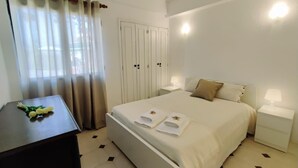 Ein Hotelzimmer mit Bett, zwei Nachttischen, einem Schreibtisch und einem Kleiderschrank.