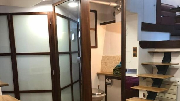 Een modern interieur met een houten vloer, een schuifglazen deur en een trap met houten treden.