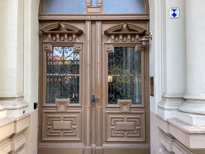 A double door with intricate ironwork and a sign above it.