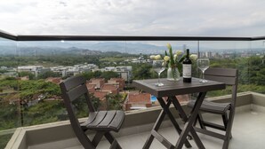 A balcony with a table, two chairs, and a bottle of wine. - LUXURY STUDIO (Cali)