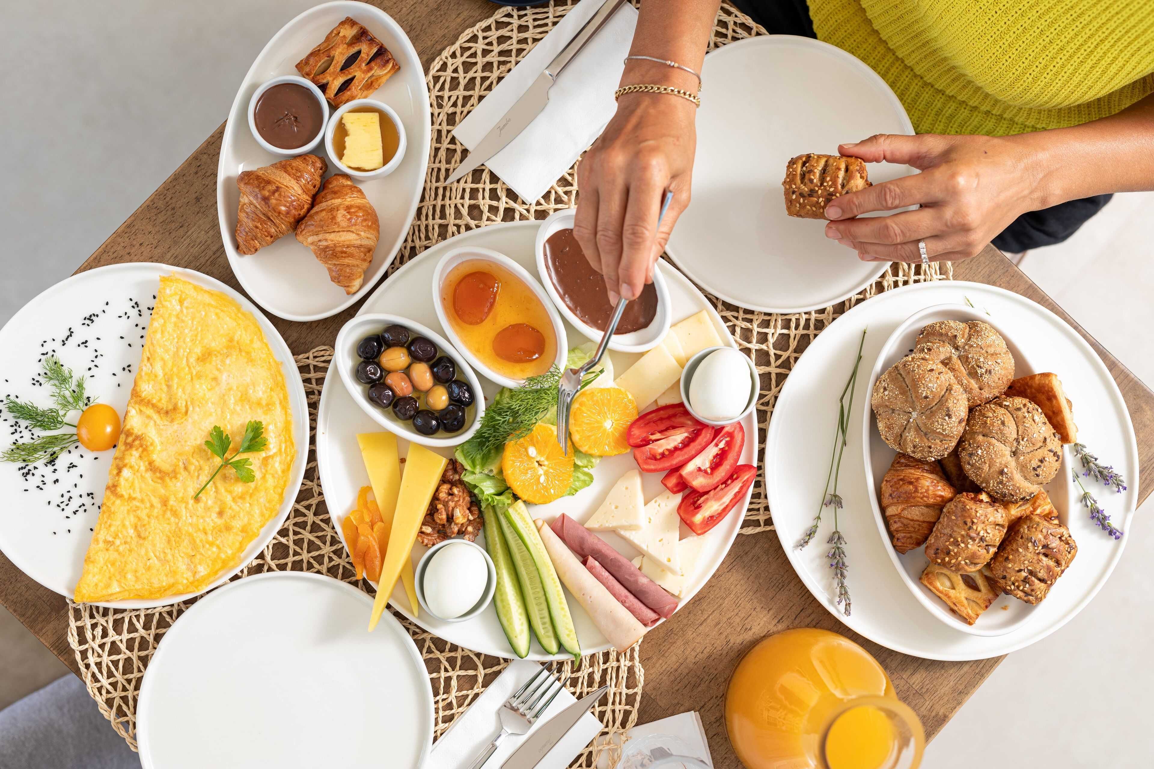 A breakfast setting with various dishes including eggs, pastries, and fruits.