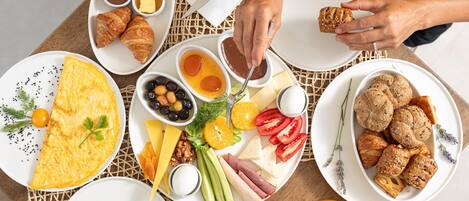 A breakfast setting with various dishes including eggs, pastries, and fruits.
