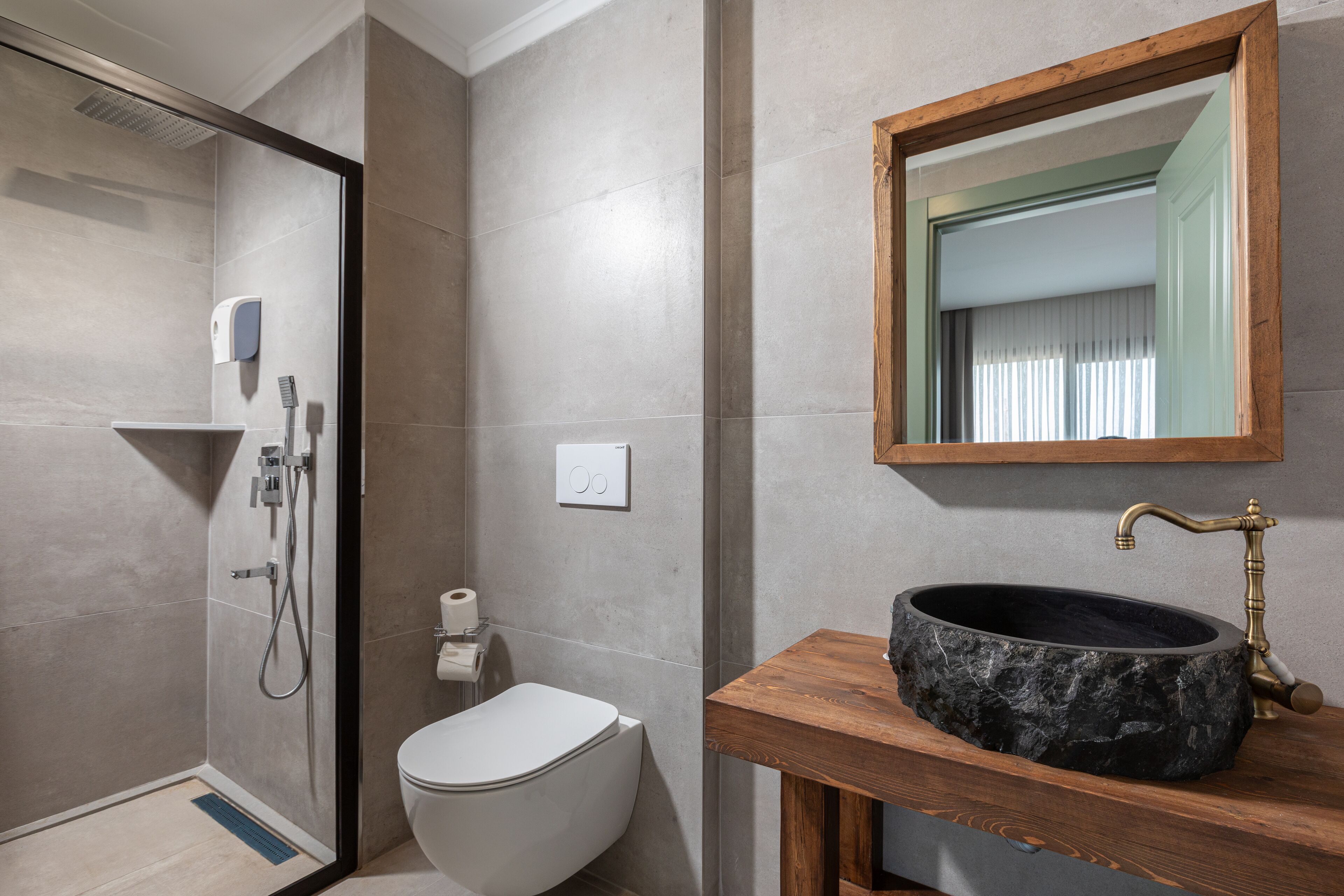 Ein modernes Badezimmer mit Dusche, Toilette und Waschbecken mit einer Holzabdeckung.