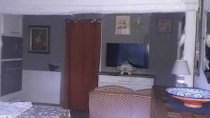 A compact living space with a kitchenette, a television, and a dining area. - Appartement 4pers (Naussac Fontanes)