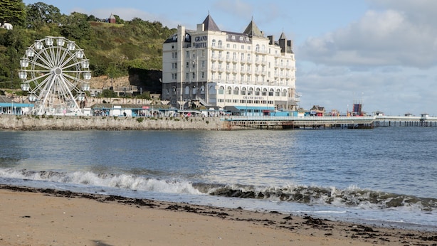Un hôtel situé sur la côte, doté d’une grande grande roue et d’une jetée qui s’avance dans l’eau.