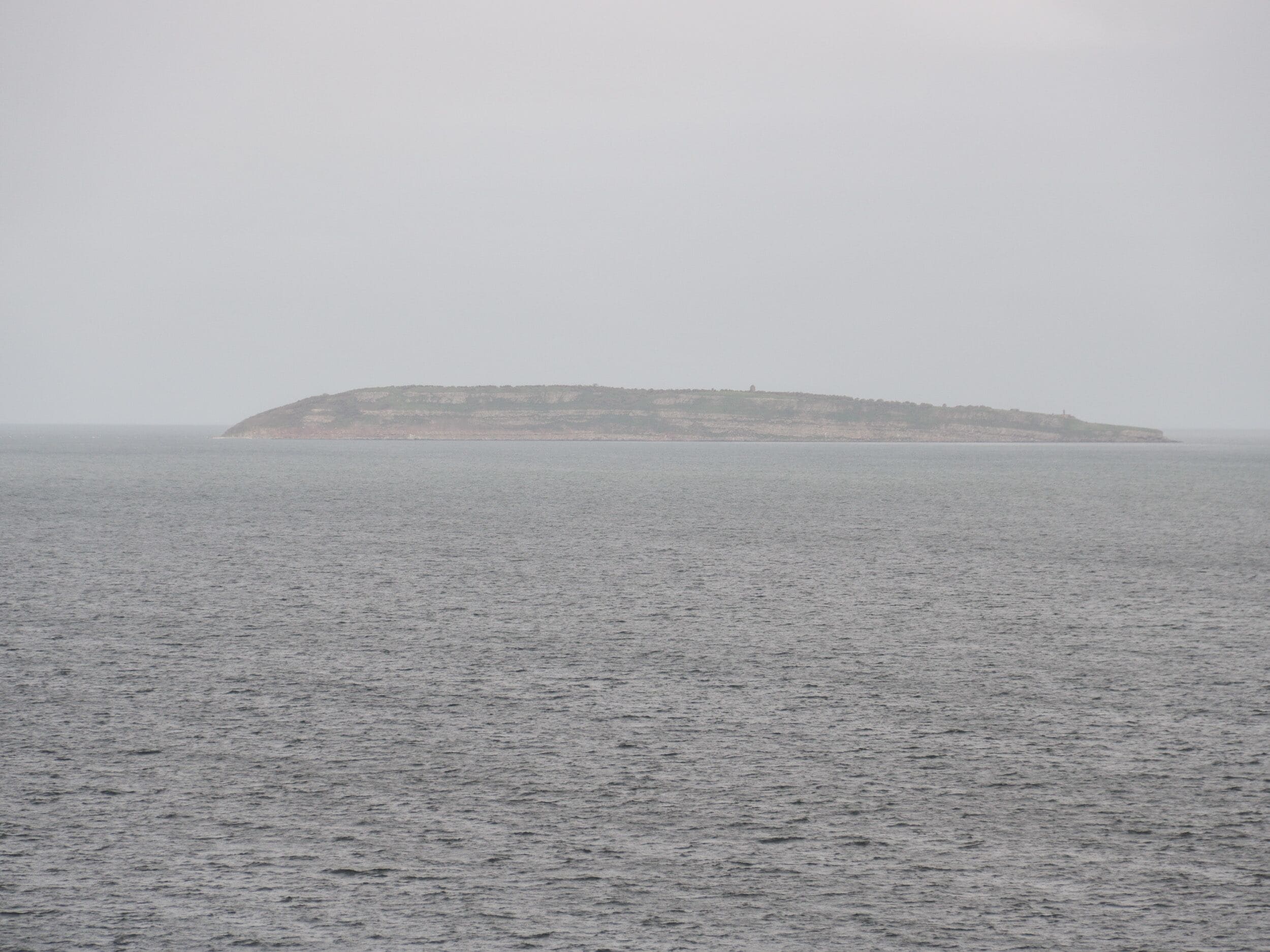 Un paisaje costero con una pequeña isla a lo lejos.
