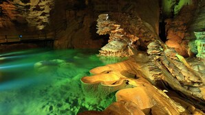 A cave with stalactites and stalagmites, a pool of water, and a staircase. - Maison 5/6 Pers Piscine Prive sur 6000 m2 (quissac)