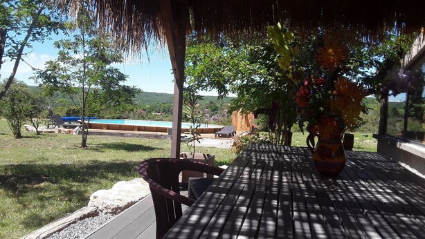 A covered patio with a view of a swimming pool and a grassy area. - Maison 5/6 Pers Piscine Prive sur 6000 m2 (quissac)