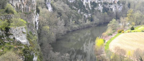 Un río serpentea por un valle con acantilados escarpados y vegetación densa.