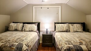 A bedroom with two beds, a ceiling fan, a window with blinds, and a nightstand with a lamp. - Redford Tranquil Retreat (Redford Charter Township)