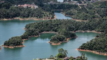 Um terreno à beira do lago com vários edifícios, rodeado por uma floresta densa e corpos d'água.