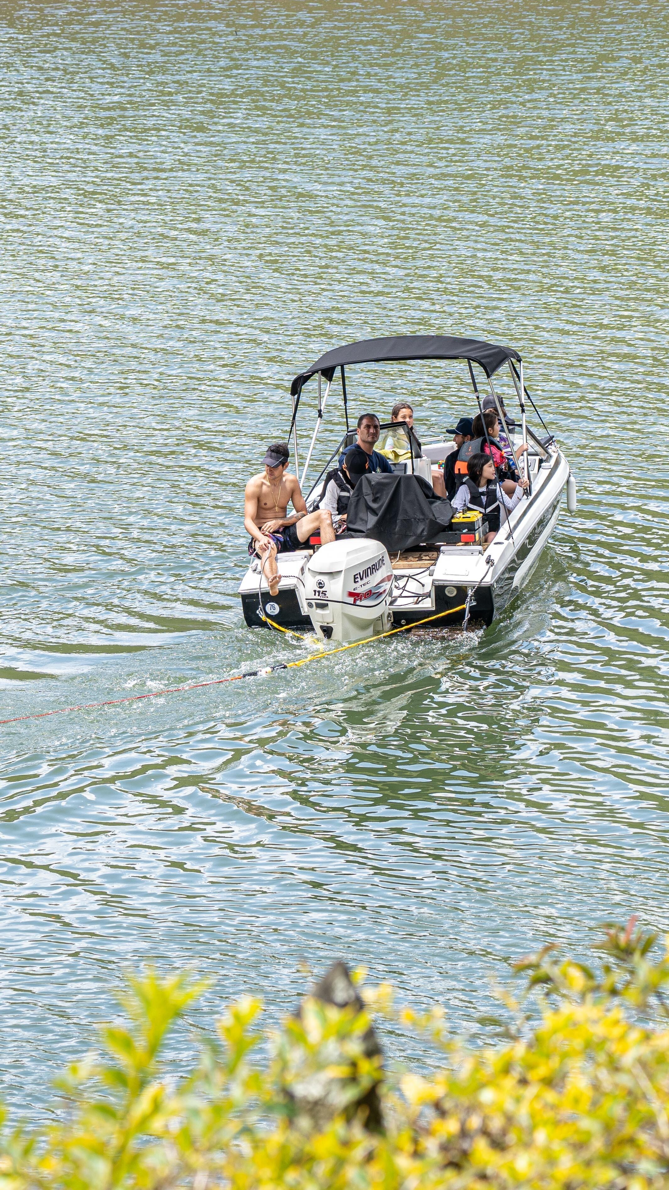 A boat with several people on it, moving through a body of water.