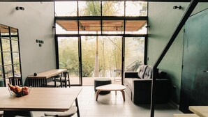 Un interior moderno con zona de comedor, sofá y escalera.