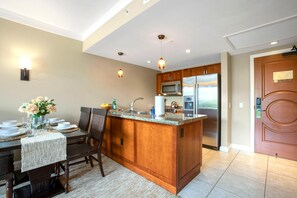 Una cocina moderna con armarios de madera, electrodomésticos de acero inoxidable y una isla central.