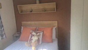 A bed with a headboard, two pillows, and a stuffed toy. - 3 Bedroom Caravan Near Mablethorpe (Louth)