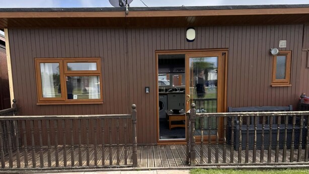 A brown building with a satellite dish, a door, and a window. - D5 Rickardos Holiday Lets (Mablethorpe)