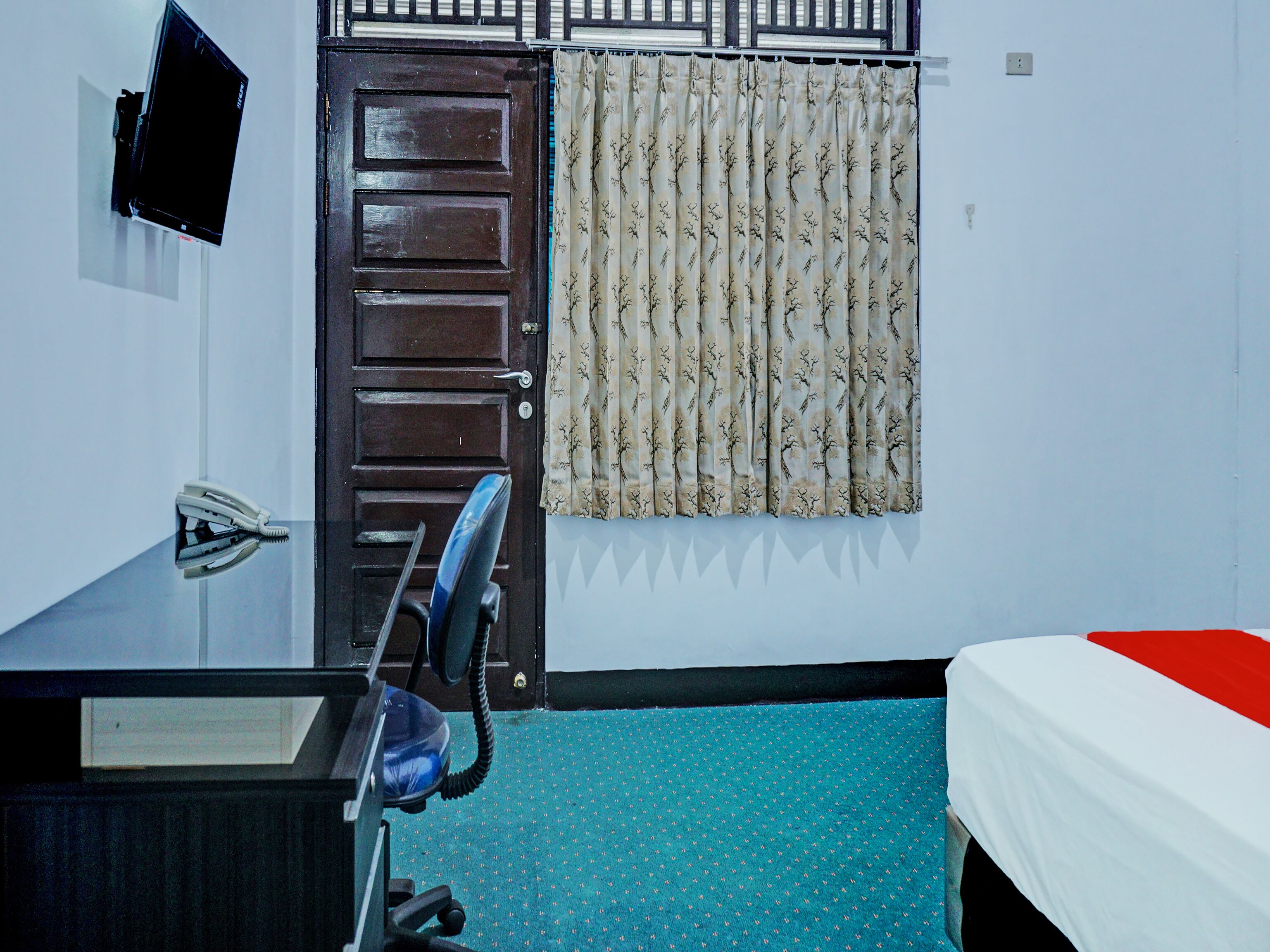 A room with a desk, chair, and a bed.