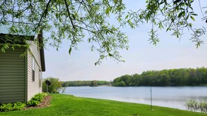 Une maison avec une cour verdoyante et un lac.