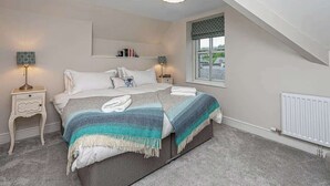 Een slaapkamer met een bed, twee nachtkastjes, een raam met uitzicht en een plafondlamp.