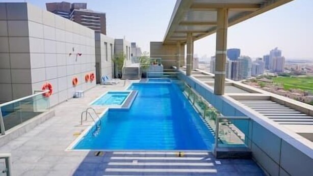 Una piscina en la azotea con vistas a la ciudad, rodeada de arquitectura moderna.