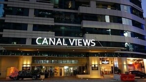 Un hotel chiamato "CANAL VIEWS" con un design architettonico moderno, caratterizzato da diversi piani e ampie finestre.