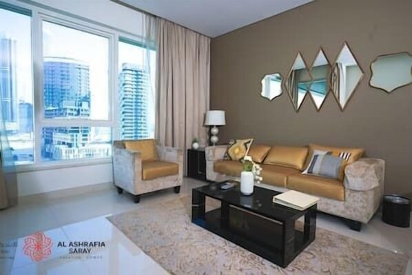 A modern living room with a sofa, two armchairs, a coffee table, and a view of tall buildings through large windows. - Exclusive 1BR CanalView apartment in DowntownDubai (Dubai)