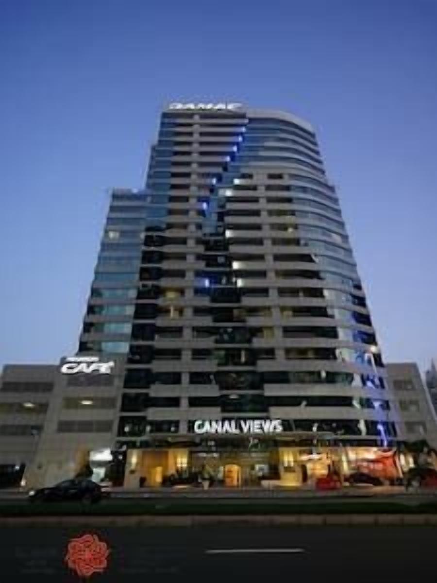 Un hotel moderno de muchos pisos, con un letrero destacado que dice 'CANAL VIEWS' y un letrero de 'CCTV' que indica cámaras de seguridad.