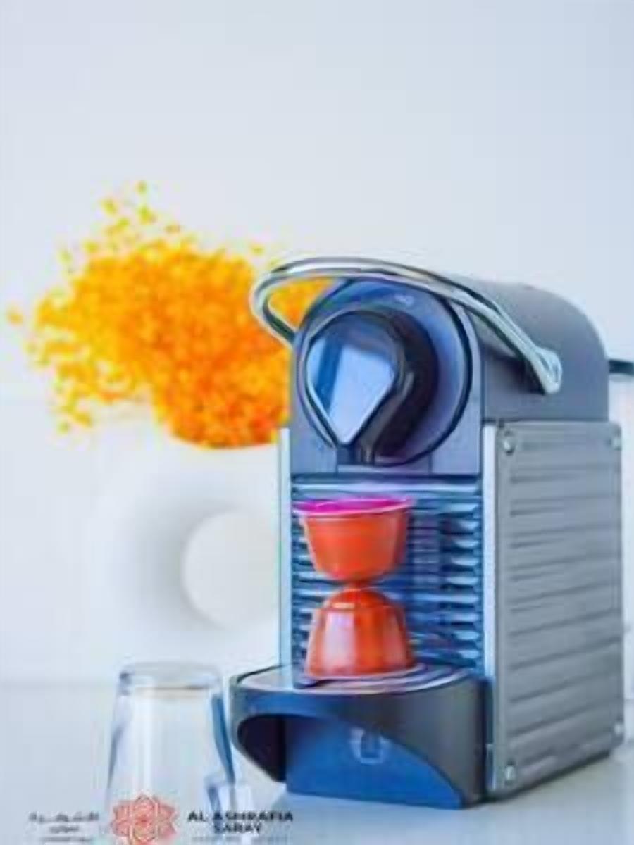 A coffee machine with a glass container and a red funnel.