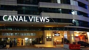 A multi-story hotel named "CANAL VIEWS" with a prominent entrance and a visible sign.