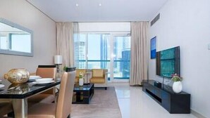 A modern living room with a dining area, large windows, and a city view.
