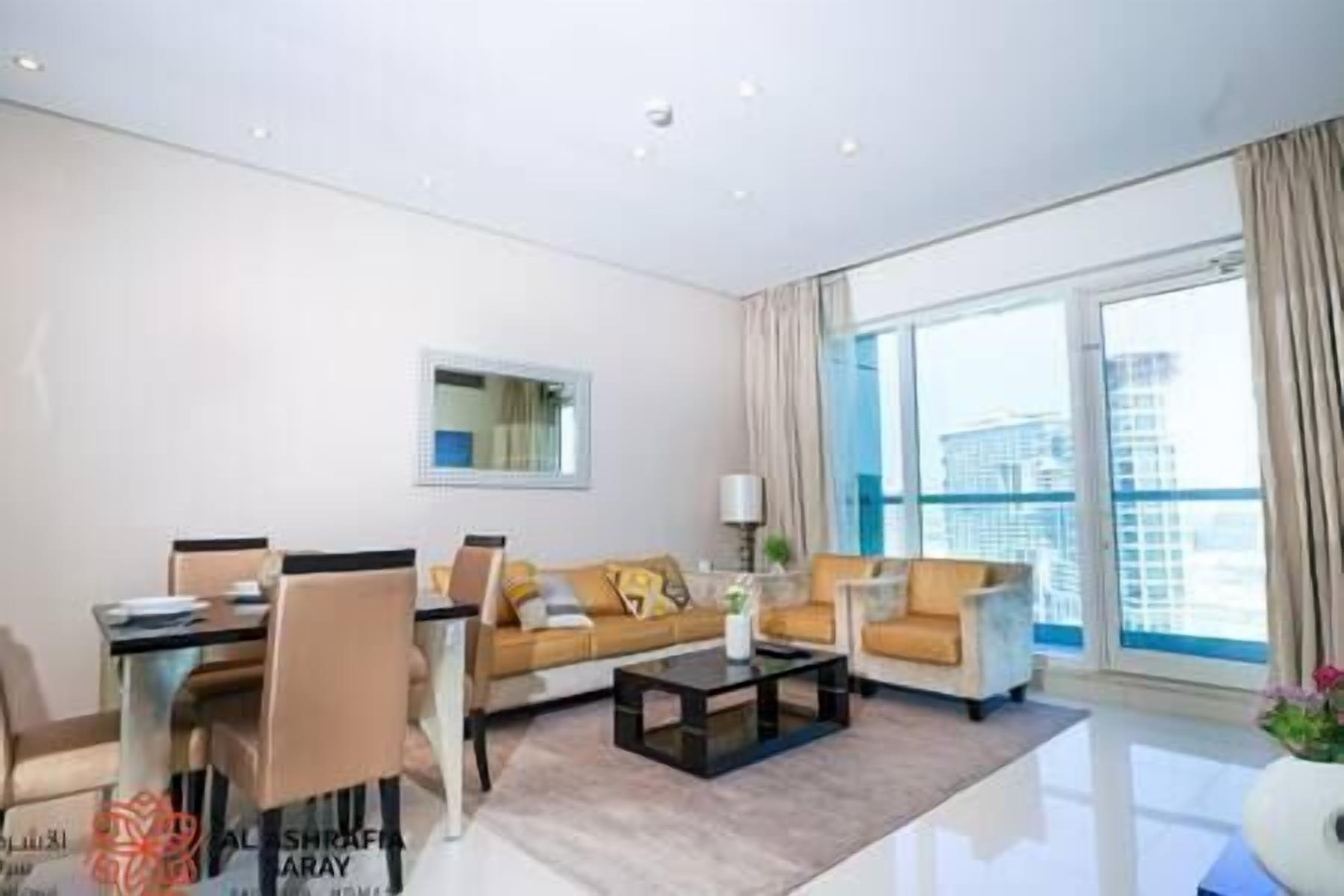 A modern living room with a sofa, coffee table, and a dining area.
