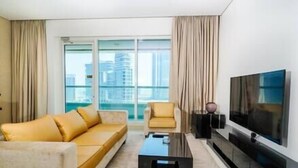 Een moderne hotelkamer met een bank, fauteuil en een flatscreen-televisie.
