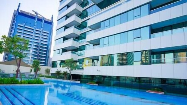 Een modern hotel met een zwembad, meerdere verdiepingen en een combinatie van glazen en betonnen architectuur.