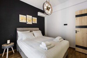A modern bedroom with a large bed, a round ceiling light, and artwork on the wall. - Atmospheric Apartment Near Acropolis by Cloudkeys (Athens)