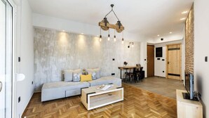 Una sala de estar moderna con un sofá, una mesa de centro y una lámpara de techo de madera llamativa.