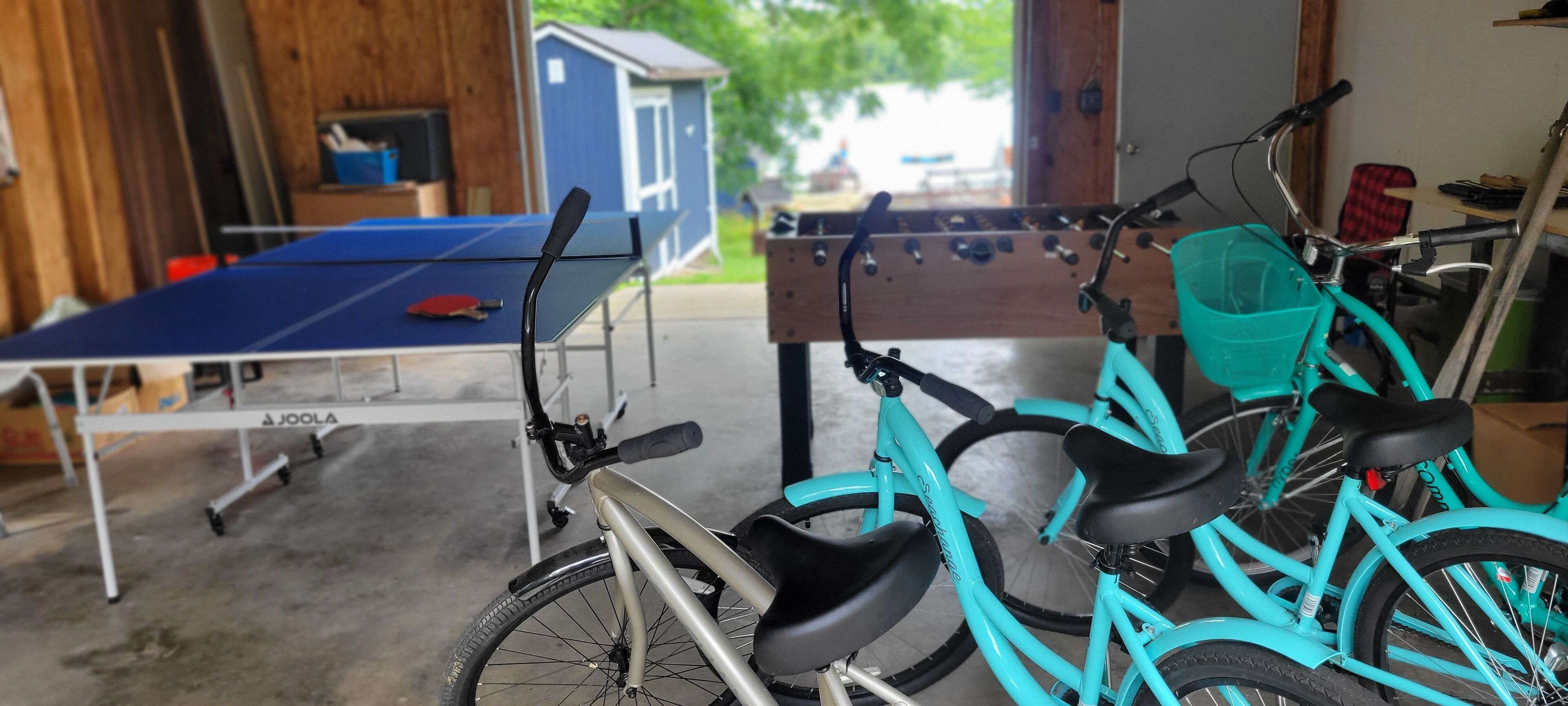 Un garage équipé d’une table de ping-pong, d’un vélo et d’un baby-foot.