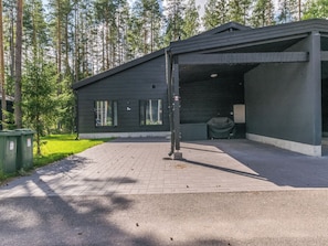 A modern building with a covered outdoor area, a paved driveway, and a grassy area with trees. - Villa väiski by Interhome (Heinola)