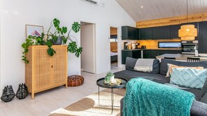 A modern living room with a sofa, a coffee table, and a cabinet with plants.
