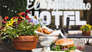 Una mesa de comedor con una hamburguesa, papas fritas y una bebida, con un cartel que dice