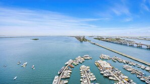 A marina with numerous boats docked, a pier extending into the water, and a distant cityscape. - Private Balcony | Biscayne Bay View | StayCozy (Miami)