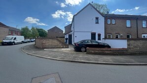 A residential street with houses, a parked car, and a van. - Remarkable Studio Flat in Cambridge (Cambridge)