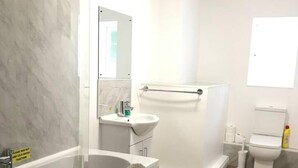 Un baño moderno con bañera, ducha, lavabo e inodoro.