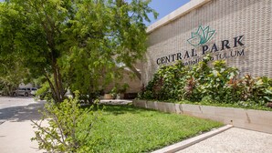 Un bâtiment sur lequel on peut lire l’inscription « Central Park », ainsi qu’un espace paysager avec de la pelouse et des plantes.