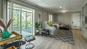 Ein geräumiges Zimmer mit großem Fenster, einem Bett, einem Schreibtisch und einem Sessel.